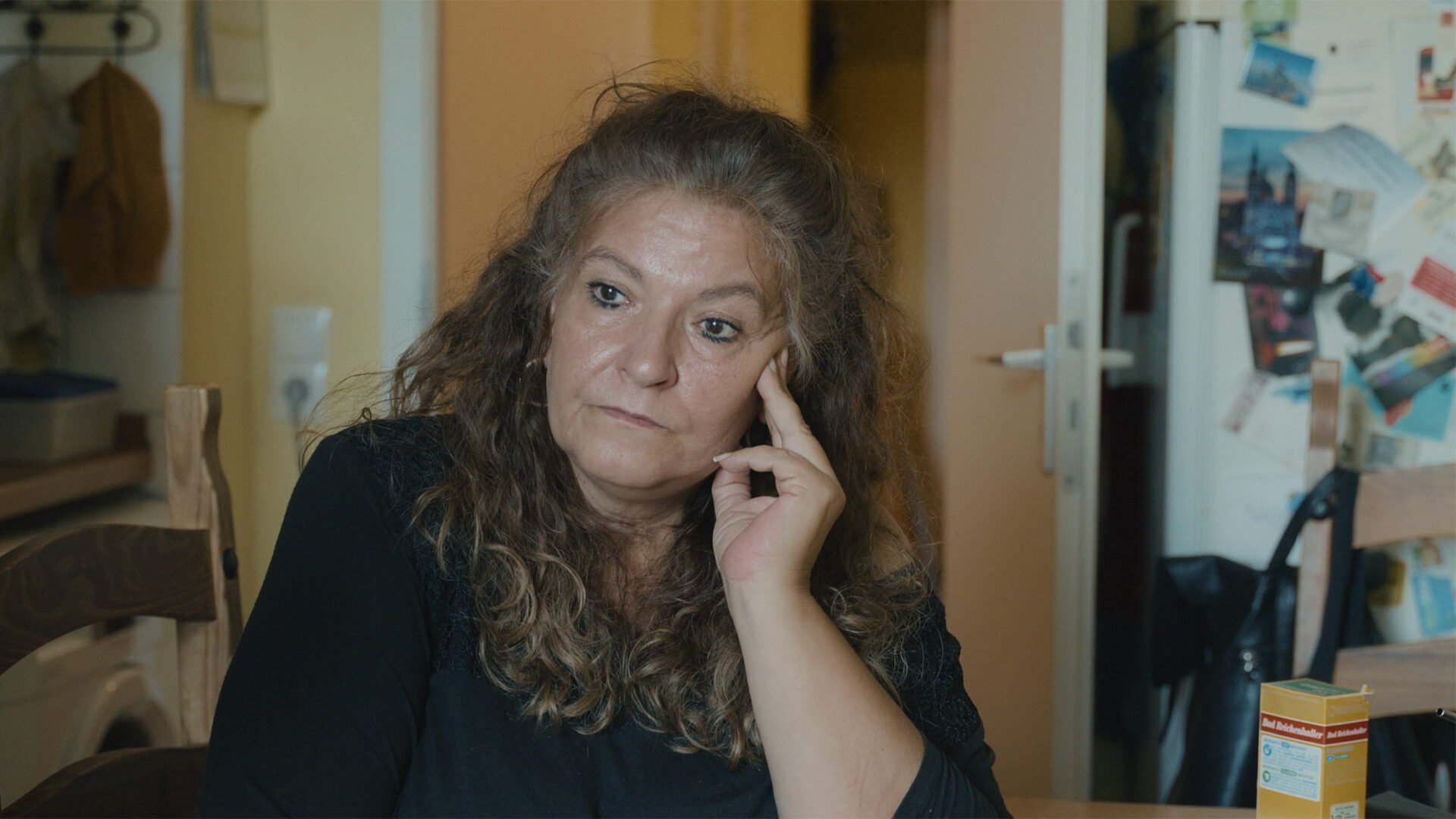 A couple of years_3_3 A woman sitting in the kitchen recalling her past life. Film still from the documentary "A couple of years".